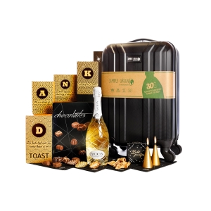 Het reiskoffer kerstpakket bevat een koffer, prosecco en etenswaren.